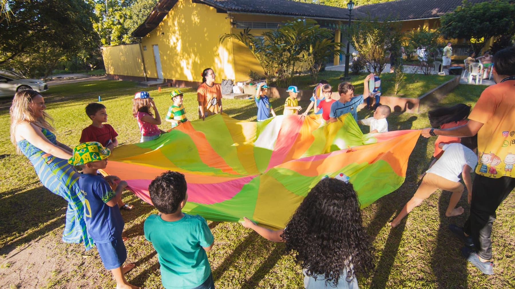 Children playing with a rainbow parachute